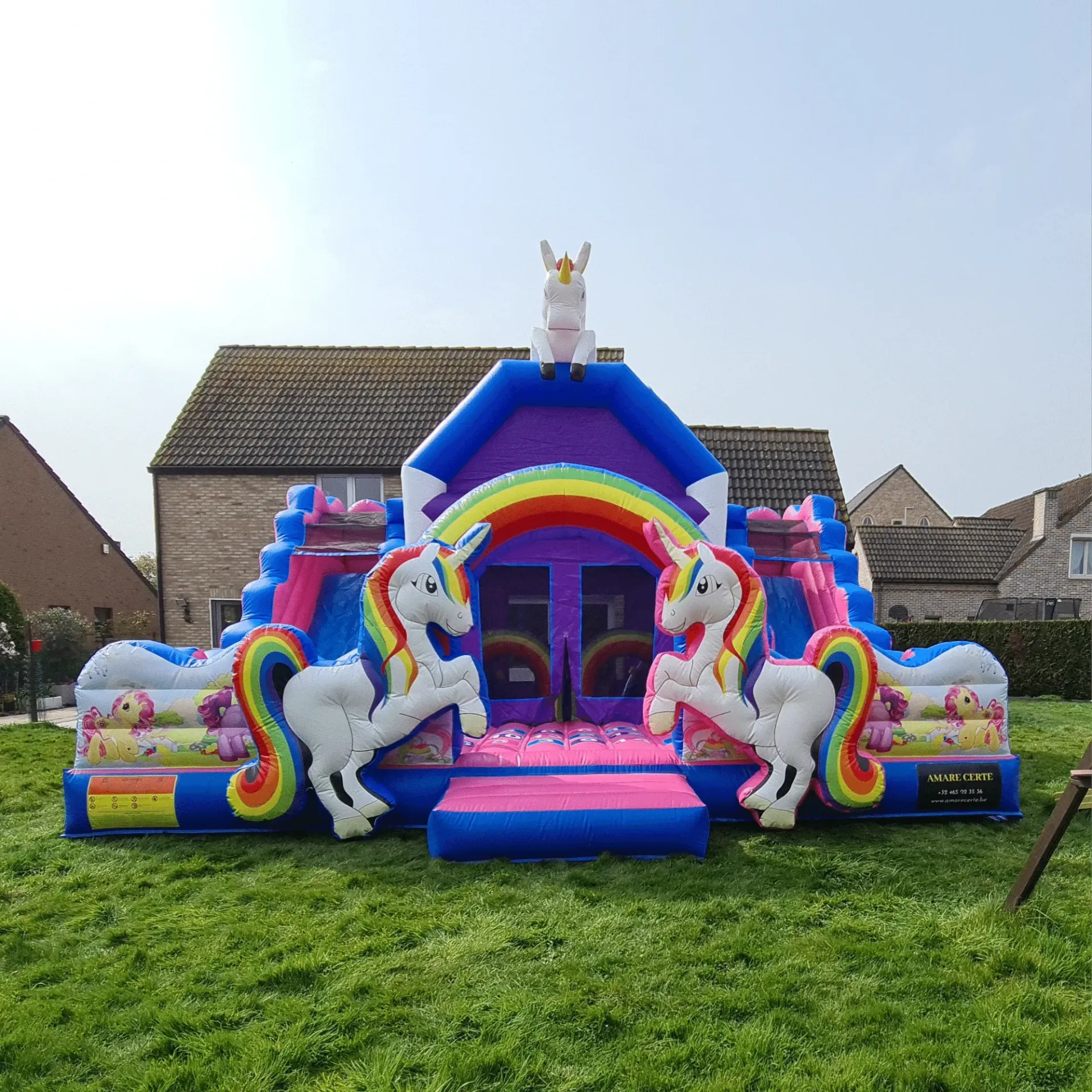 Eenhoorn springkasteel huren – kleurrijk springkasteel met glijbanen